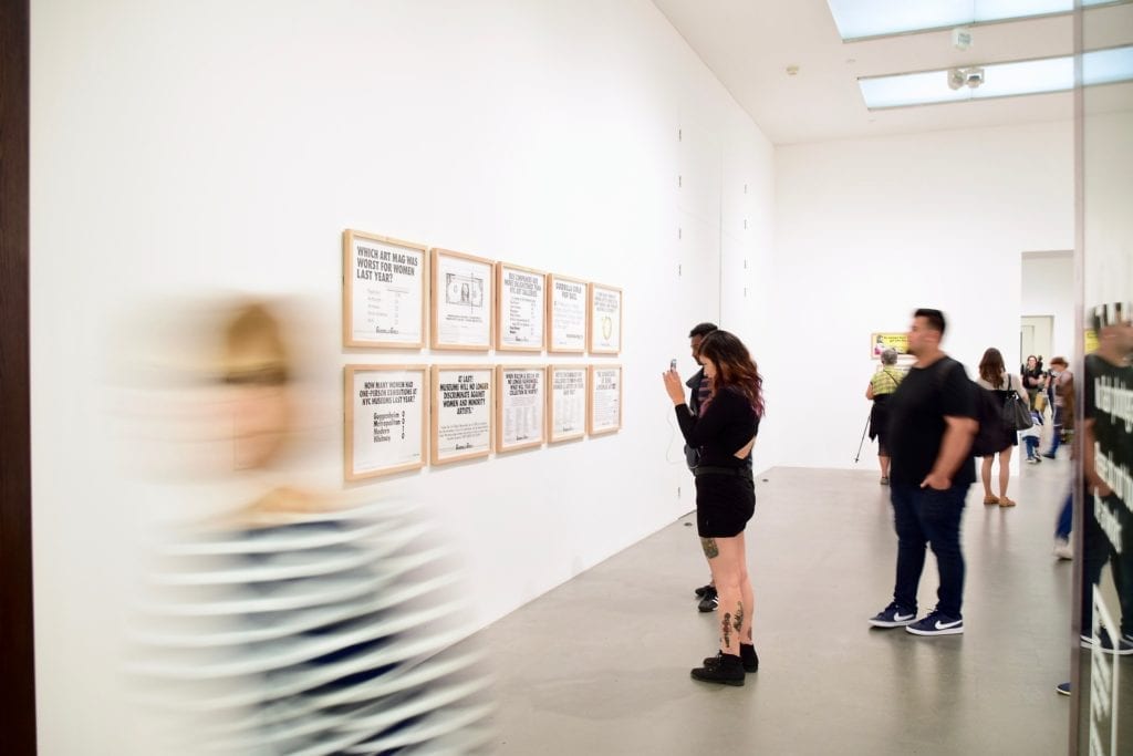 People standing in front of artwork in gallery