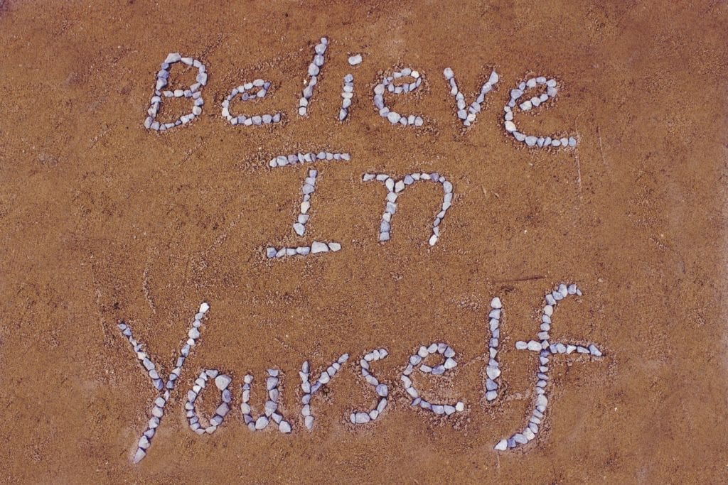 Sand with rocks spelling believe in yourself